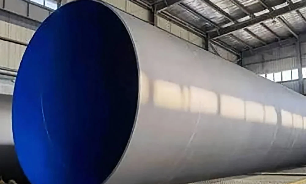 3pe coated steel pipe with a smooth white polyethylene anti corrosion coating stored in a factory workshop.